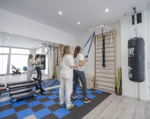 Paziente che esegue esercizi di rinforzo muscolare con elastici nella palestra riabilitativa di Alma Fisio a Firenze Novoli